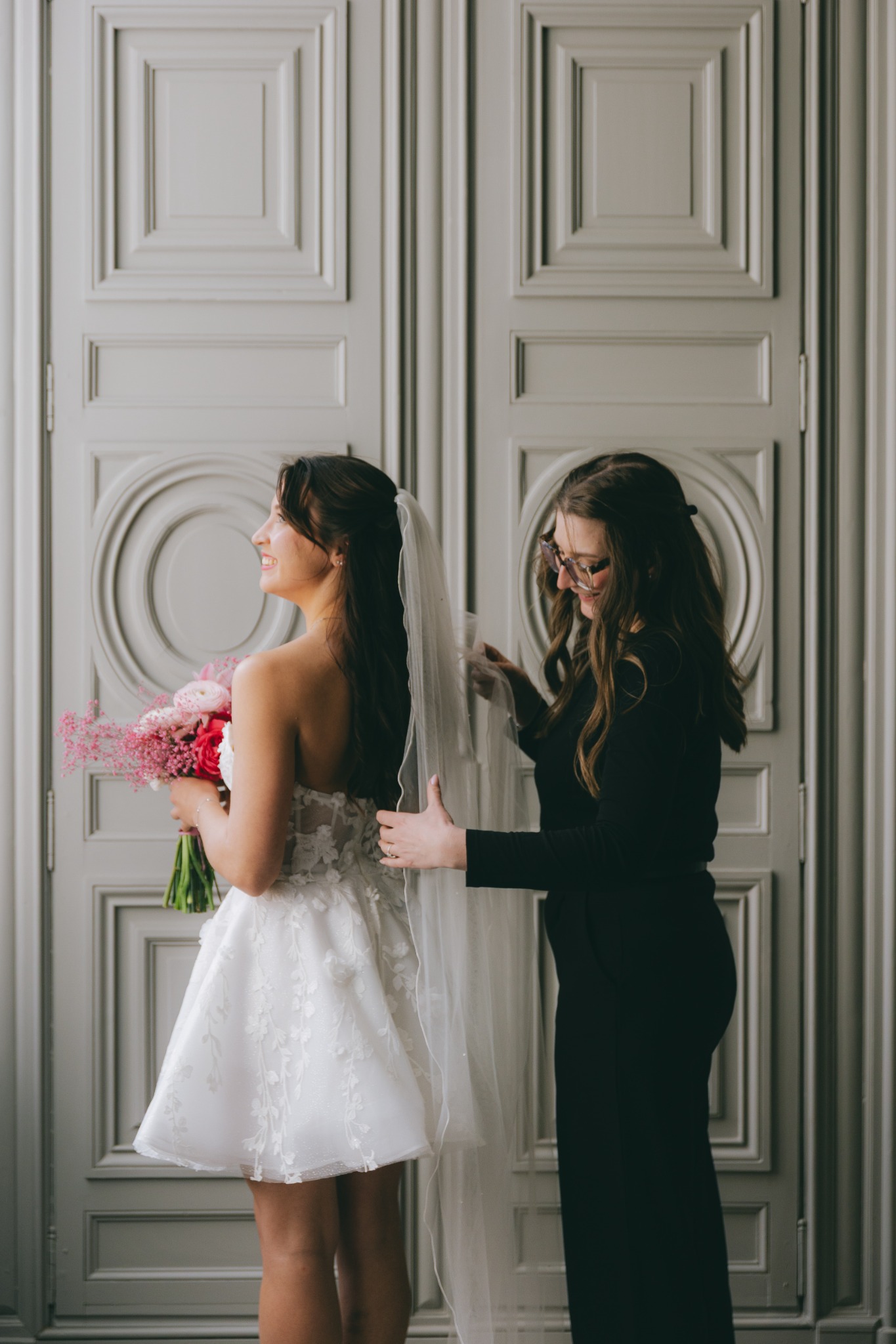 Wedding planner ajustant le voile d’une mariée